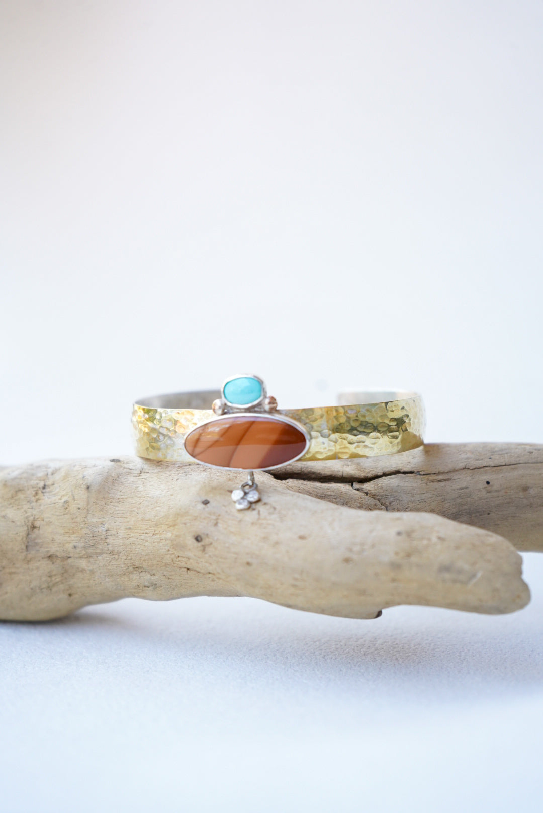 statement cuff with jasper and turquoise on a piece of driftwood