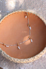 Load image into Gallery viewer, Necklace with small pearls on a woven surface