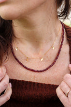 Load image into Gallery viewer, Close-up of a person wearing a gold necklace with small gold pendants and a red beaded necklace.