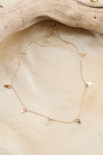 Load image into Gallery viewer, Gold necklace with gold pendants on a beige stone surface