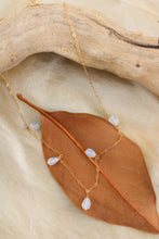 Load image into Gallery viewer, Gold necklace with opal beads on a leaf and wooden surface