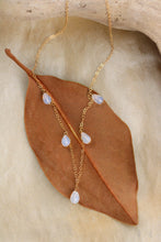 Load image into Gallery viewer, Gold necklace with opal beads on a brown leaf