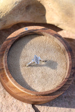 Load image into Gallery viewer, Silver ring with a vintage component design next to two baguette diamonds in a wooden box on a stone surface