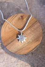 Load image into Gallery viewer, Silver necklace with a star-shaped pendant on a wooden surface