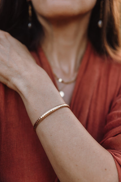 woman in a orange dress wearing a gold bracelet