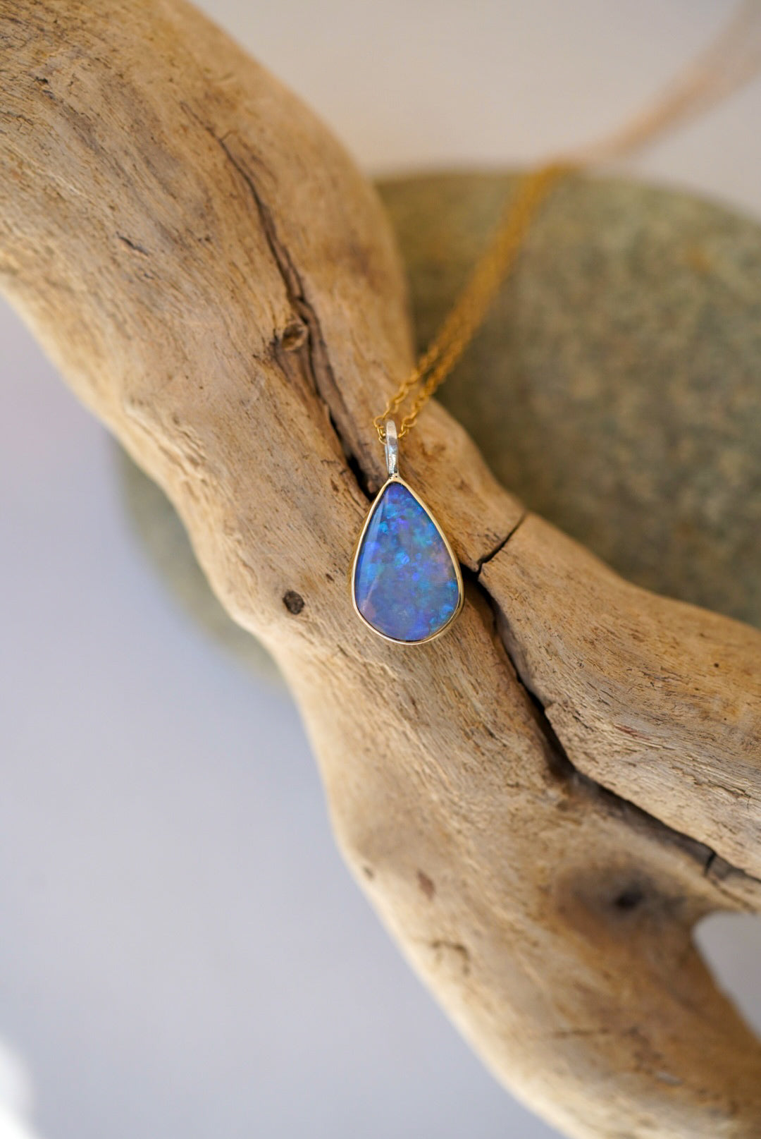 Opal pendant necklace on a wooden branch