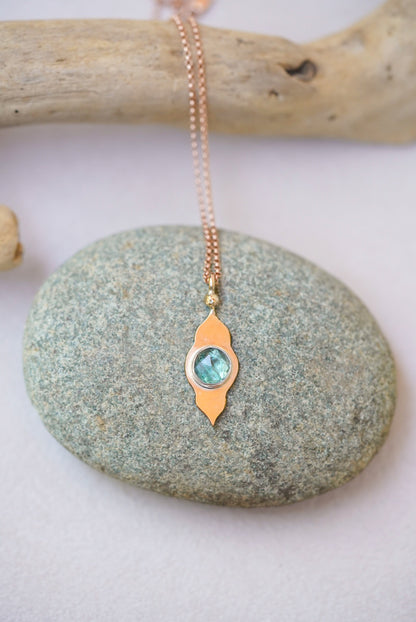 Green pendant with gold temple design on a river rock 