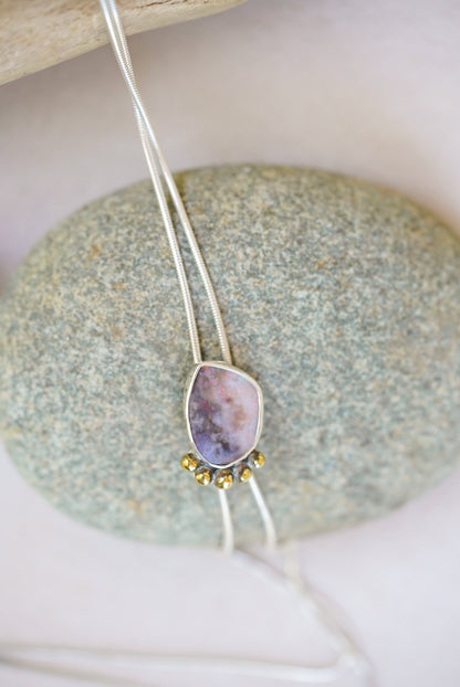 Bolo Opal Necklace with a pendant on a stone surface