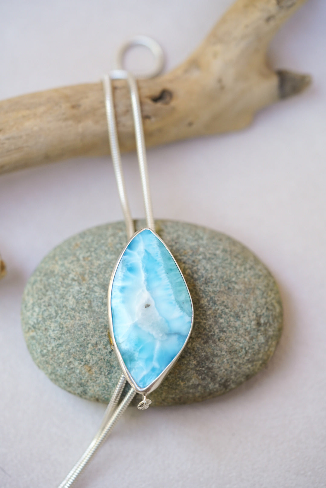 Large blue stone bolo necklace on top of a river rock