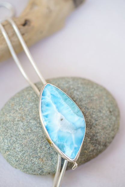 Large blue stone bolo necklace on top of a river rock