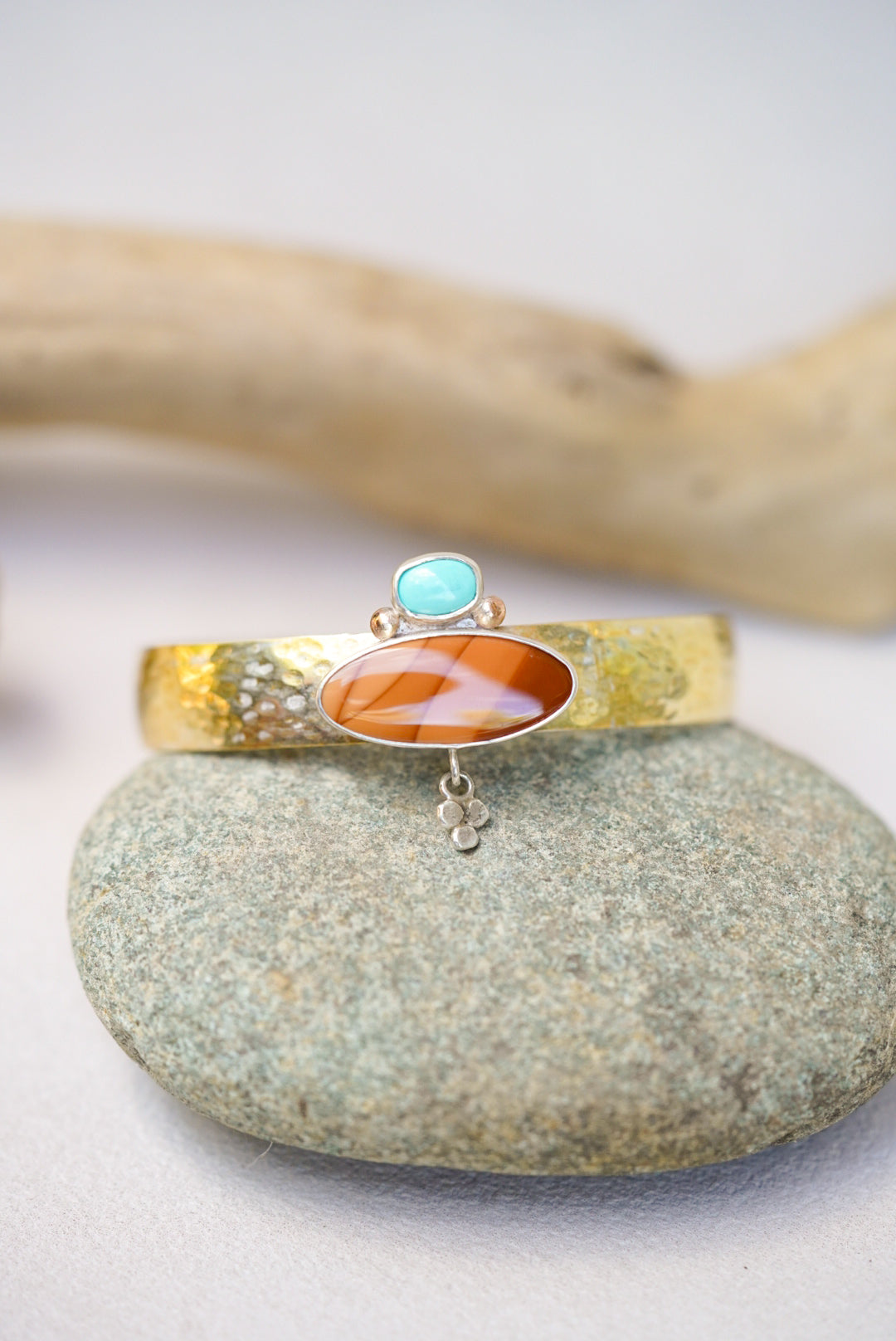 statement cuff with jasper and turquoise on a river rock