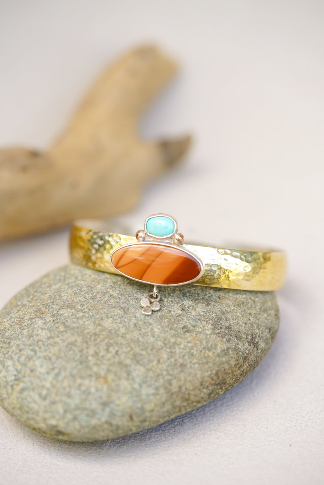 statement cuff with jasper and turquoise on a river rock