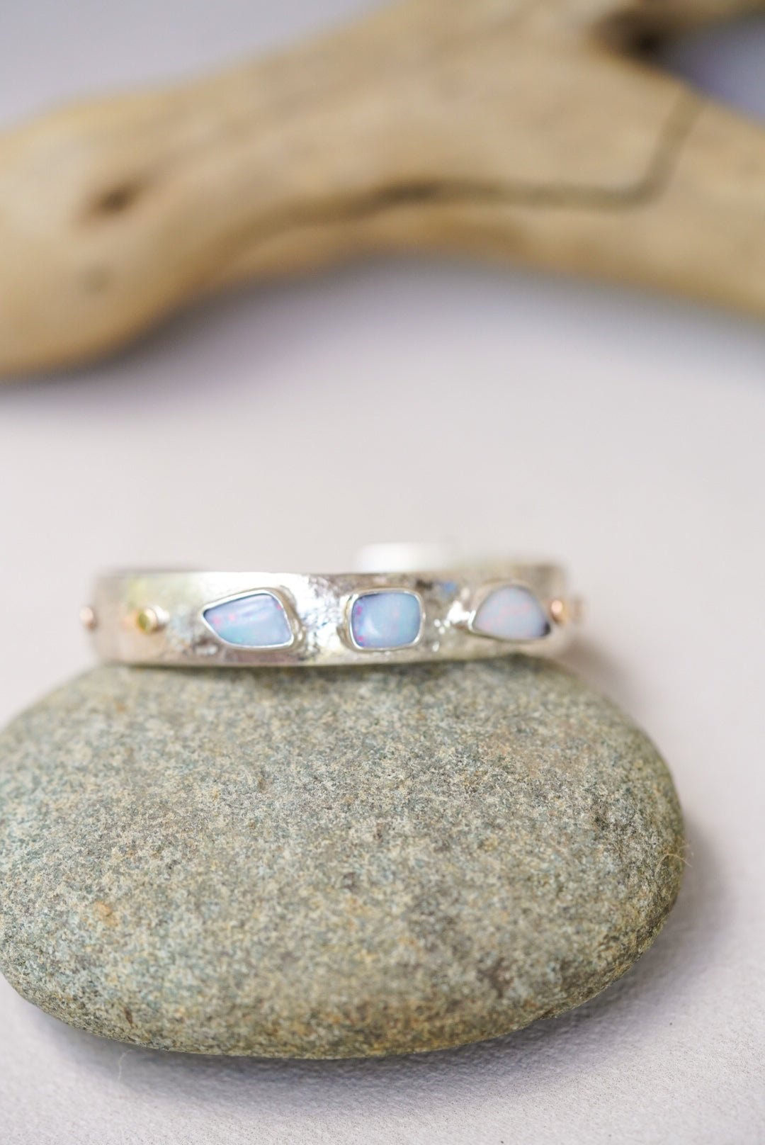 Silver bracelet with opal stones on a stone surface