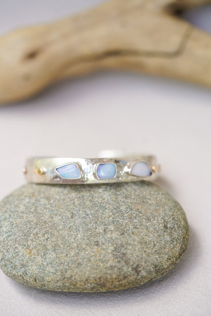 Silver bracelet with opal stones on a stone surface