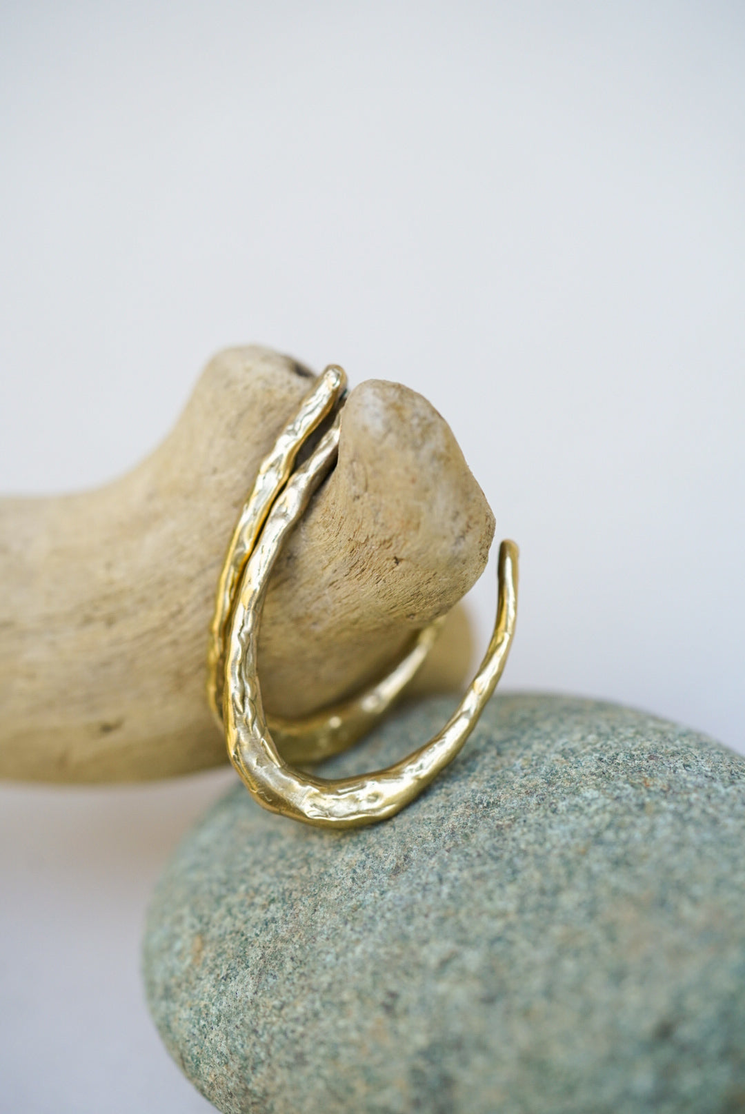 Gold earrings  on a rock with a white background