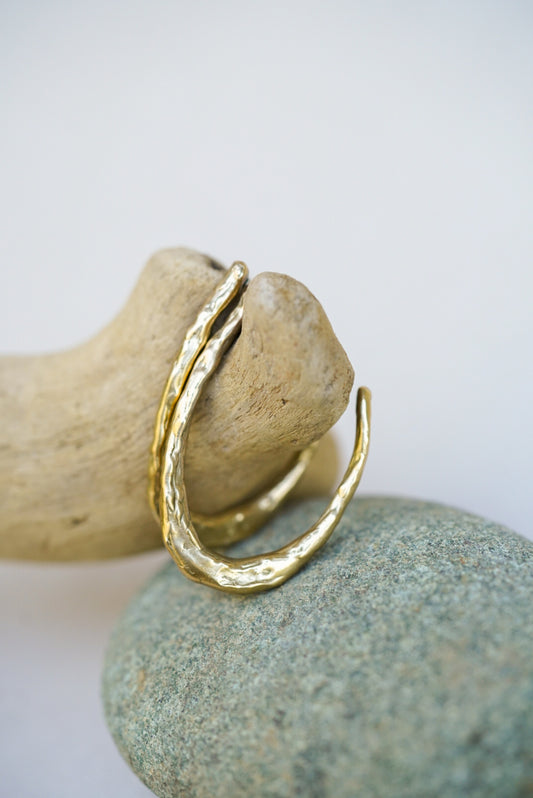 Gold earrings  on a rock with a white background