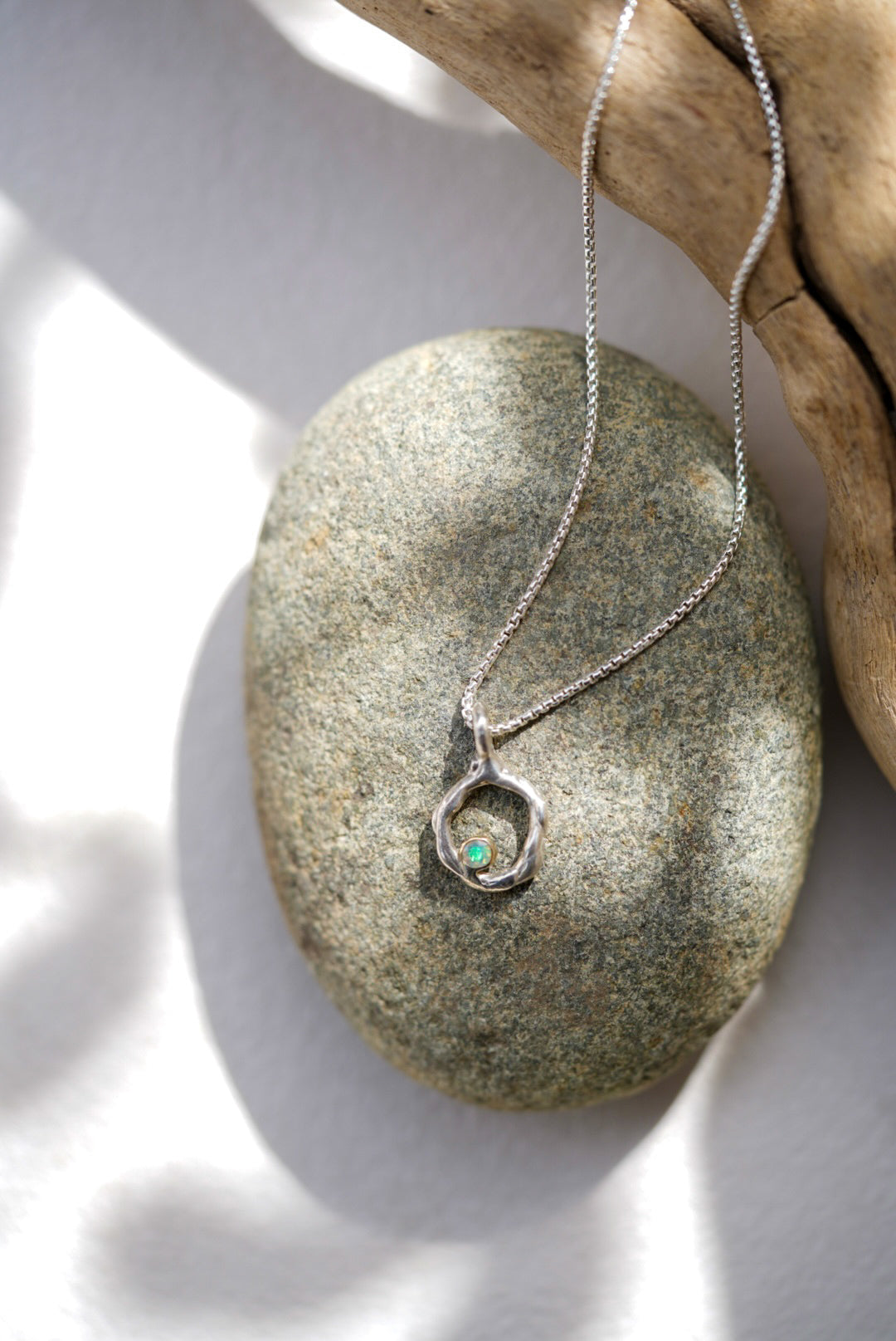 Silver necklace with a pendant on a stone surface