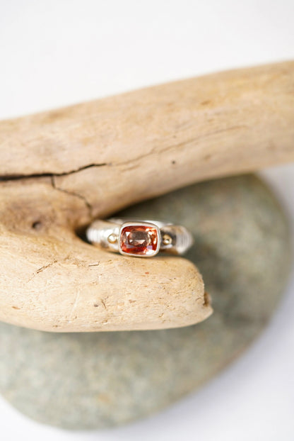 Sunstone silver ring next to a piece of driftwood
