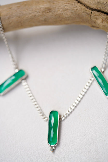 Necklace with green pendants on a white background