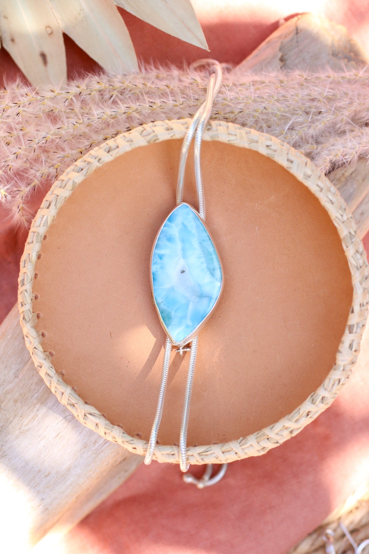 Bolo necklace with a blue pendant on a textured surface