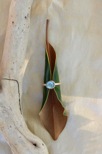 Gold ring with a aquamarine gemstone on a leaf-shaped stone