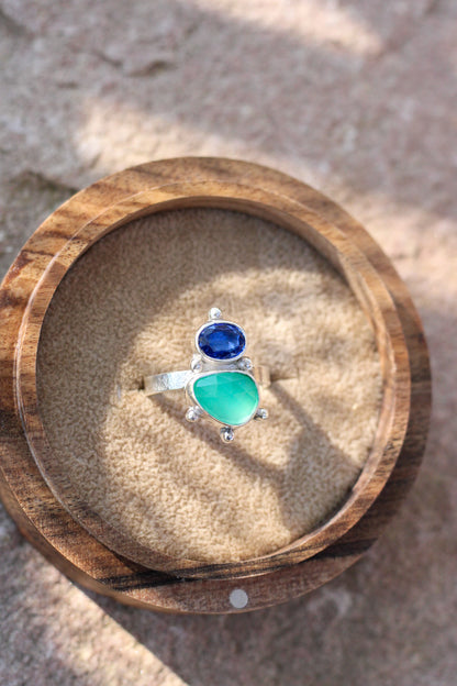 cobalt blue kyanite and green chalcedony ring on a wood ring box on a neutral background