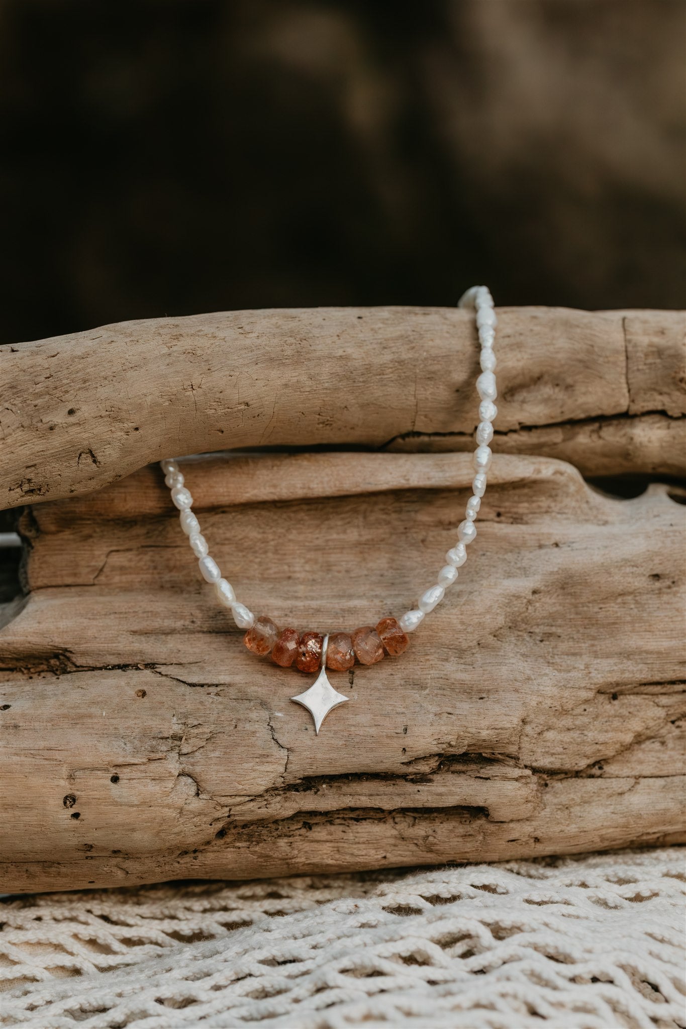 Necklace with a star pendant on a piece of driftwood