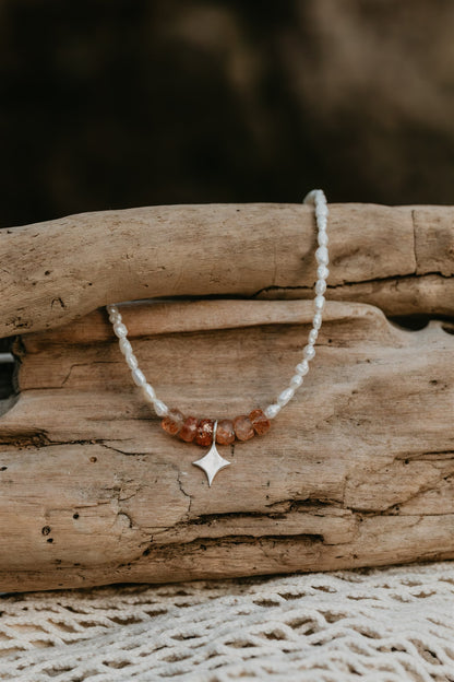 Necklace with a star pendant on a piece of driftwood