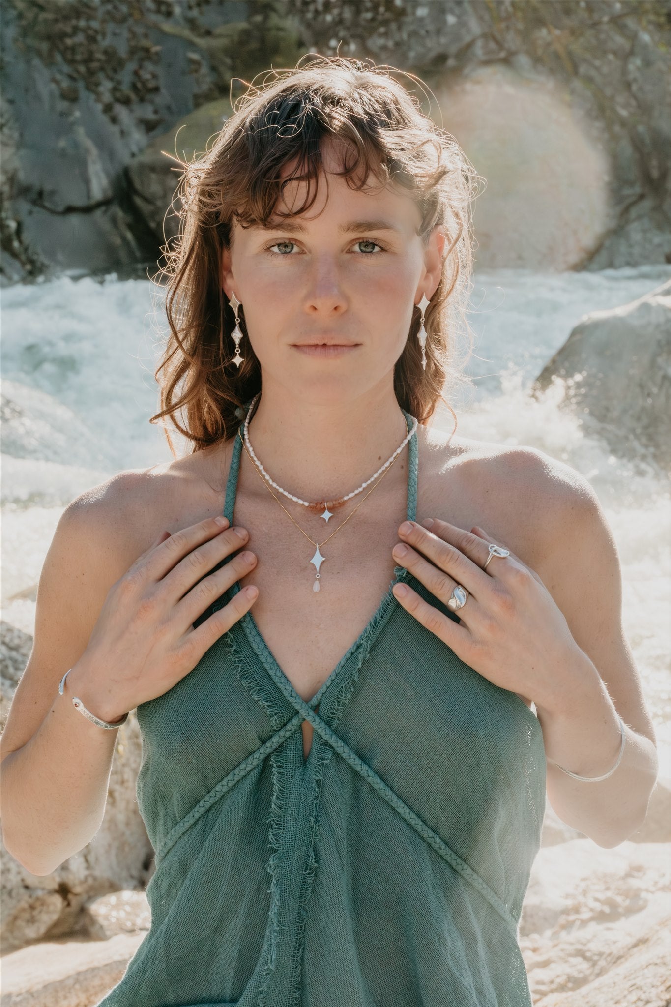 Woman wearing a green dress with jewelry in a natural setting