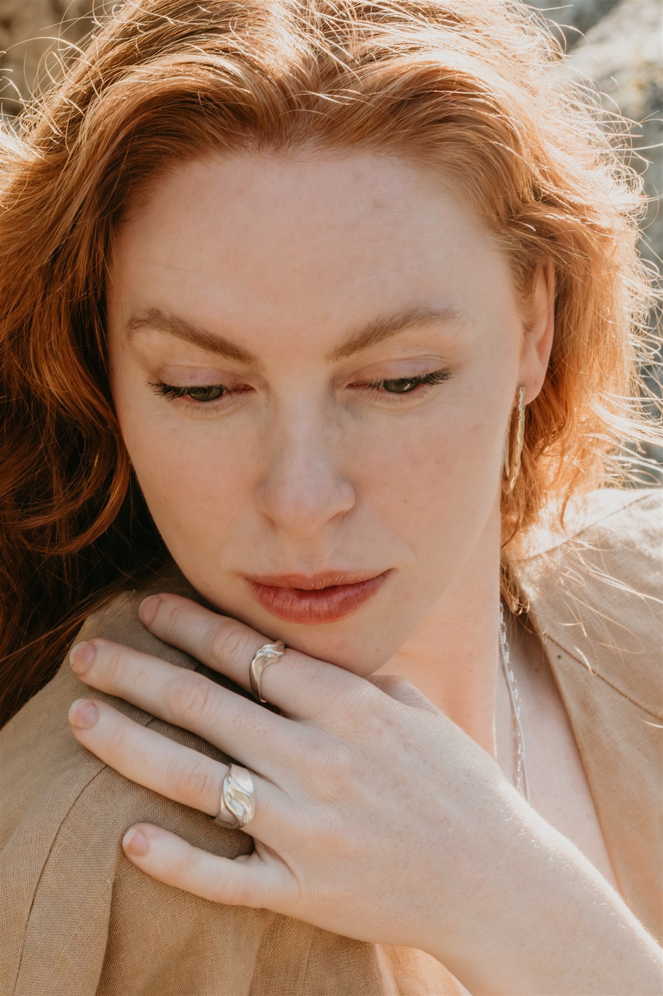 Woman wearing a ring, close-up of face and hand.