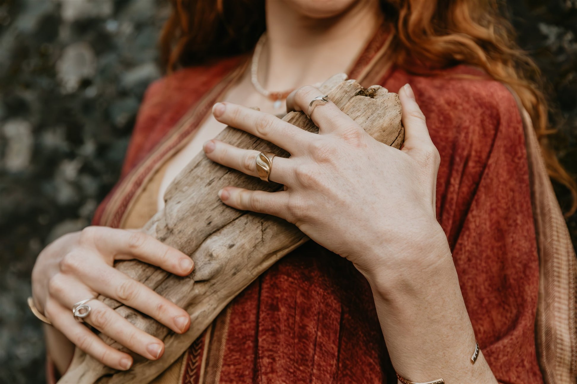 Person holding a piece of wood with a blurred natural background
