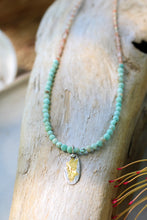 Load image into Gallery viewer, A turquoise and sunstone beaded necklace with a gold fill pendant and clasp, displayed on a wooden surface.

