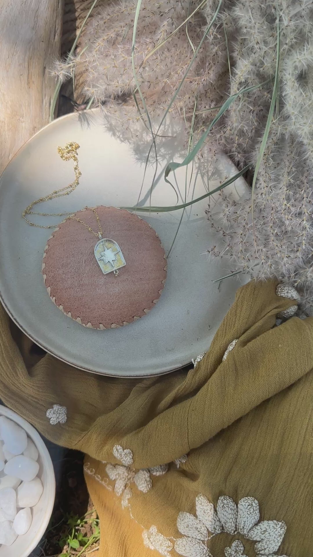 video of arch-shaped pendant with a star detail and a small diamond hanging below